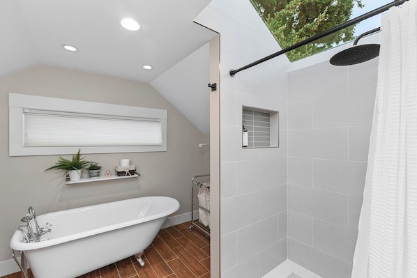 A bathroom with a freestanding bathtub, a shower with a rain showerhead, and a window with blinds. - Madrona Bliss A Modern Escape (Seattle)