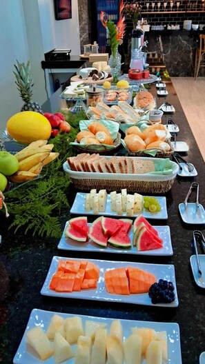 En buffet med forskelligt frugt, brød og desserter.