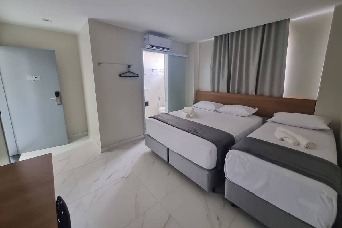 A hotel room with two beds, a bathroom, and a door marked with the number 206.