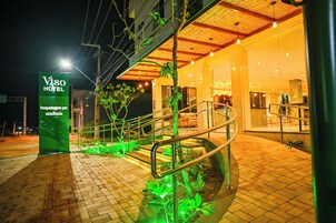 Vista nocturna de la entrada del Hotel Viso, con un diseño moderno que incluye una escalera y un cartel.
