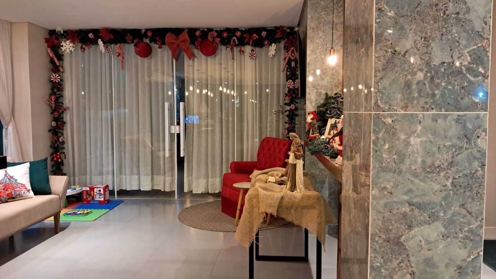 Een woonkamer met een rode bank, een klein rond tafeltje en een kerstboom.