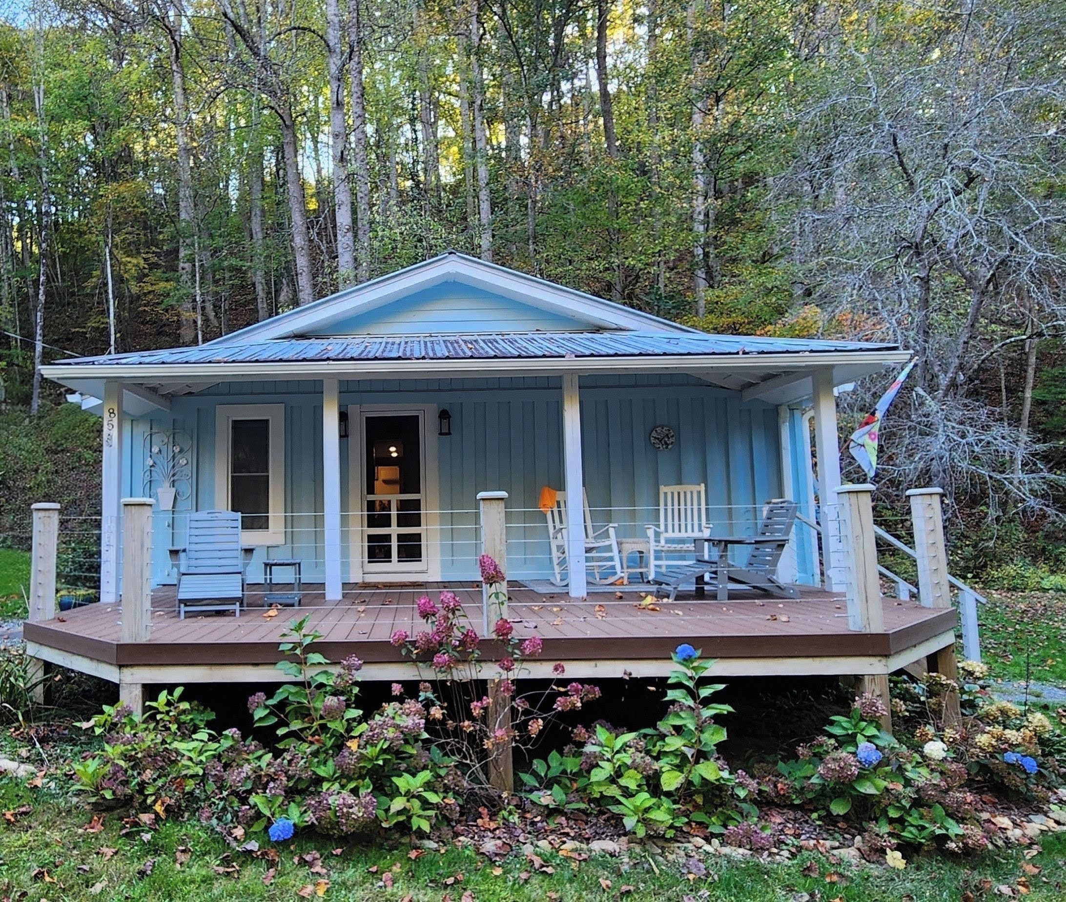 A two-story house with a porch, a covered deck, and a front door.