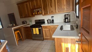 Una cocina con armarios de madera, estufa, lavabo y encimera.