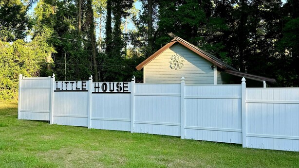 Ett inhägnat område med en skylt som lyder: ”Lilla huset”.
