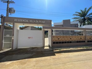 A gated entrance to a residential villa with a sign reading 'RESIDENCIAL VILLA DA PRAIA.' - Condomínio com Piscina á 500m da Praia (Porto Seguro)