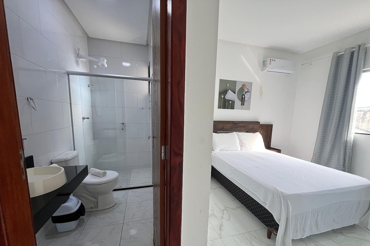 A hotel room with a shower, toilet, and a bed.