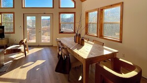 A spacious room with a high ceiling, large windows, and a wooden floor. - Modern A-Frame Cabin, Sleeps 12, Cedar Hot Tub, Game Room, Fishing Pond, Views (Ellijay)
