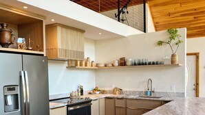 A modern kitchen with a marble countertop, stainless steel appliances, wooden cabinets, and a wooden ceiling. - Modern A-Frame Cabin, Sleeps 12, Cedar Hot Tub, Game Room, Fishing Pond, Views (Ellijay)