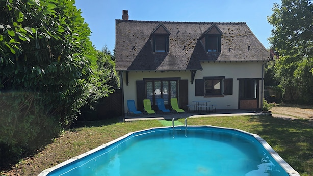 Een zwembad met een huis op de achtergrond.