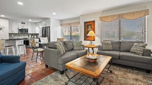 A modern living room with a sofa set, a coffee table, and a dining area with a chair.