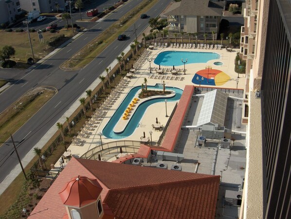 Une piscine sur le toit, dotée de chaises longues, et un petit bâtiment avec un toit rouge.