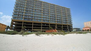 A multi-story hotel with a large parking garage, located near a sandy beach. - Sunrise Pointe 11F (North Myrtle Beach)