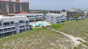 A resort with multiple buildings, a swimming pool, and a beachfront view. - Sea Cloisters 101d (North Myrtle Beach)