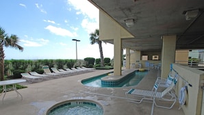 Un espace piscine avec des chaises longues et un jacuzzi.