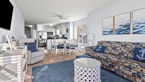 Un salon moderne avec un canapé, une table basse et un coin repas.