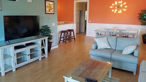 A living room with a TV, entertainment unit, and a light blue sofa. - Ocean Keyes 3941 (North Myrtle Beach)