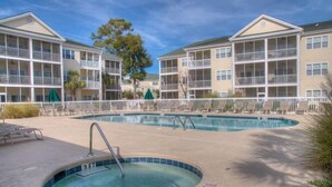 A hotel with a swimming pool, multiple balconies, and a clear sky. - Ocean Keyes 3941 (North Myrtle Beach)