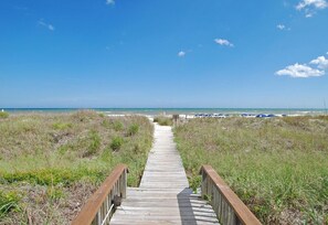 A wooden boardwalk leading to a beach with a clear sky. - Sea Cloisters 204c (North Myrtle Beach)