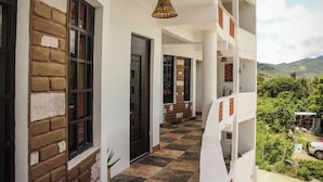 A corridor with a checkered floor, a door, and a hanging light fixture. - Hotel Yubazuu Mitla (San Pablo Villa de Mitla)