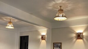 A hotel room with two beds, each with teal bedding and white trim, a small bedside table with a vase of flowers, and wall-mounted sconces. - Hotel Yubazuu Mitla (San Pablo Villa de Mitla)