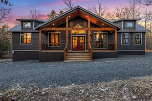 Stunning log cabin-style building with a symmetrical facade, featuring a prominent front entrance and dormer window.