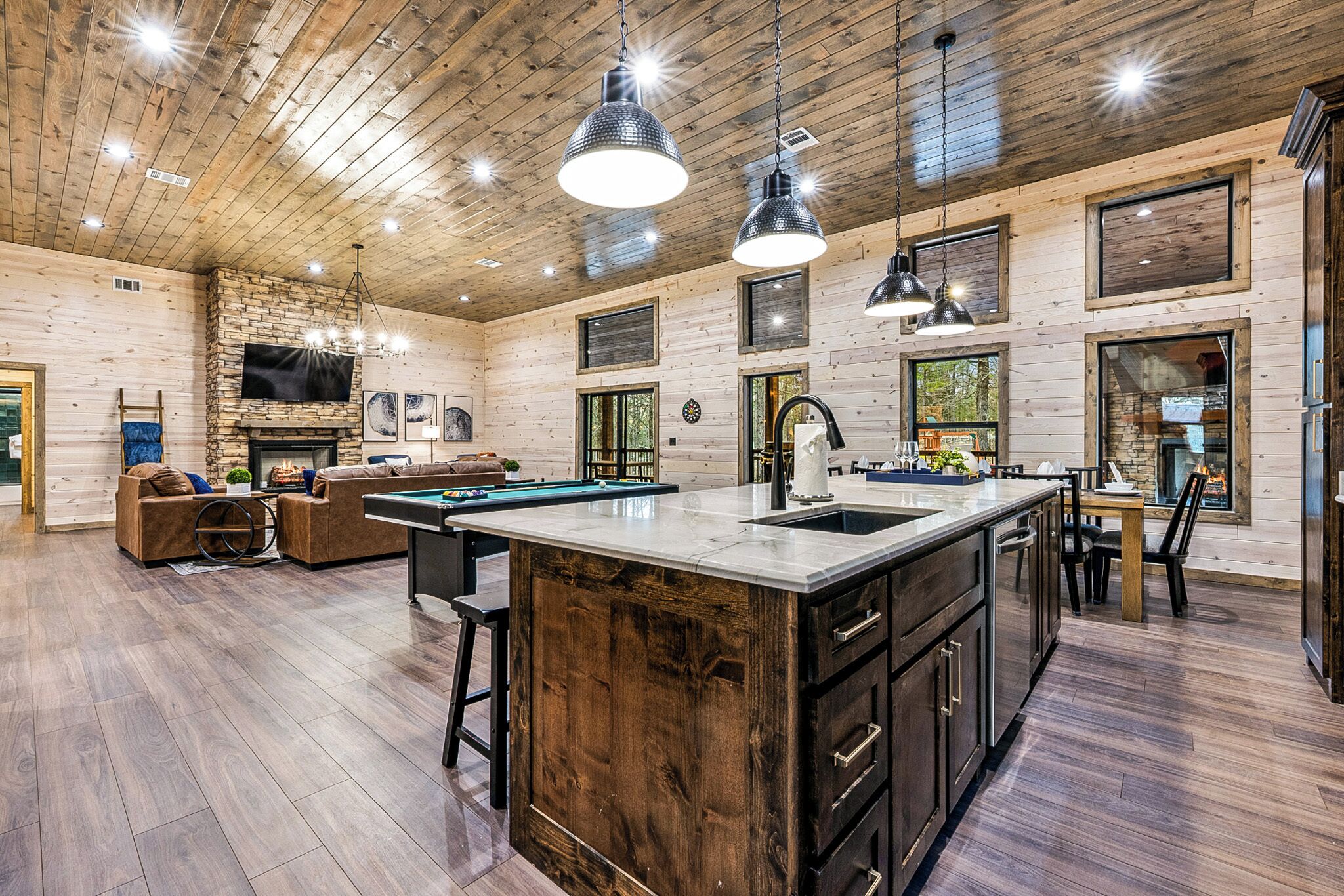 A spacious living area with a pool table, comfortable seating, and a fireplace.