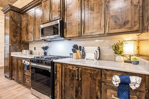 Kitchen features a sleek range hood, white countertop, and modern appliances.