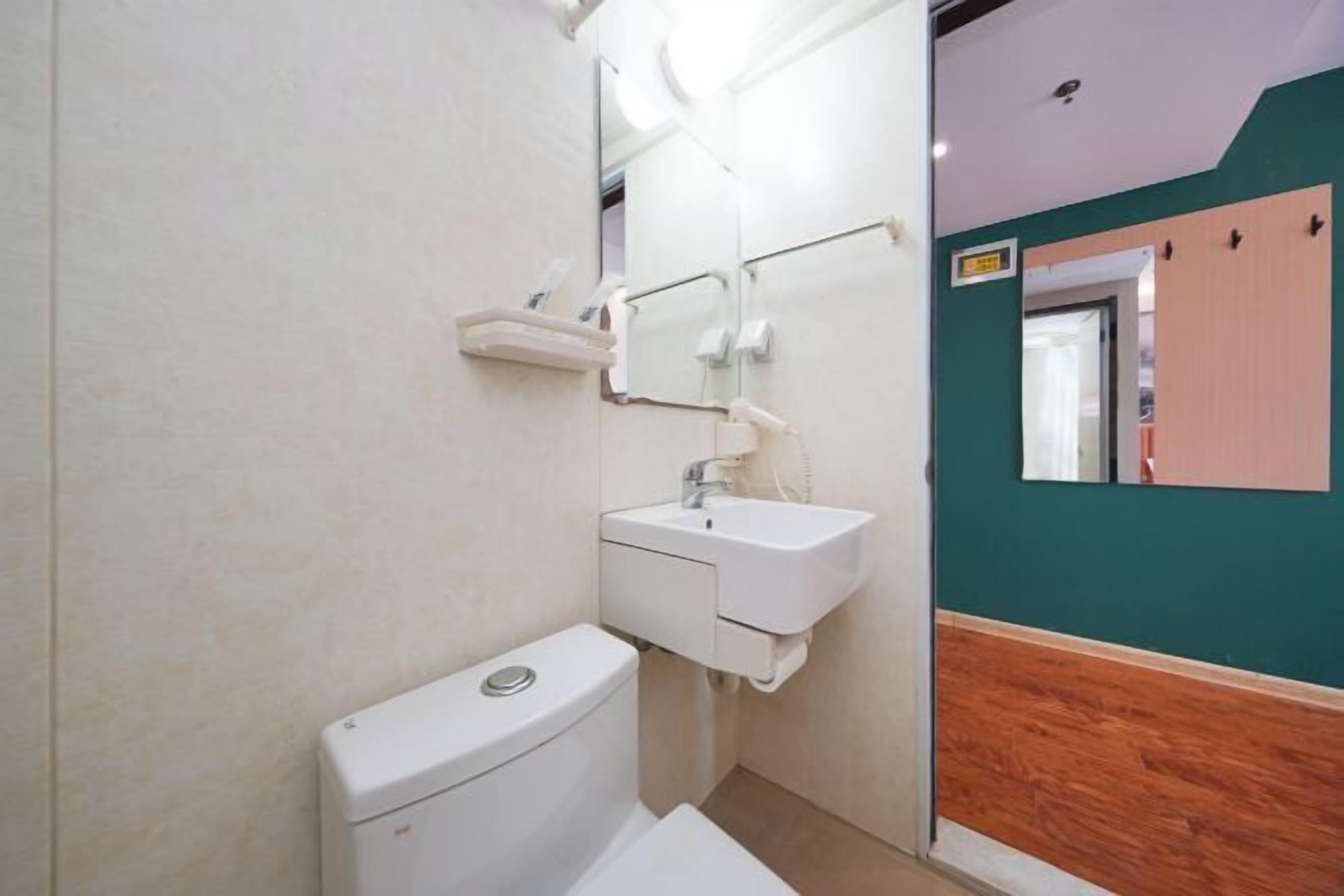 Un baño pequeño con inodoro, lavabo y espejo.