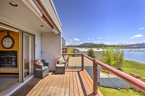 Enjoy a peaceful lakeside retreat with a deck, wicker chairs, and a table.