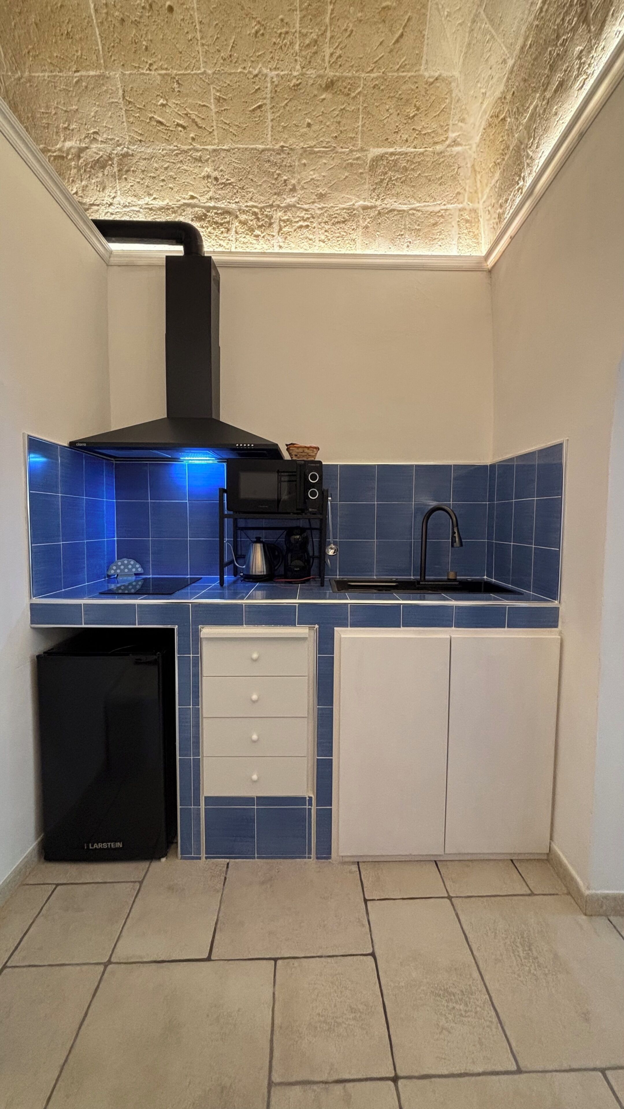 A compact kitchen with a built-in oven, microwave, and sink.