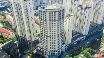 Un edificio de gran altura con diseño en esquina, rodeado de otros edificios altos.