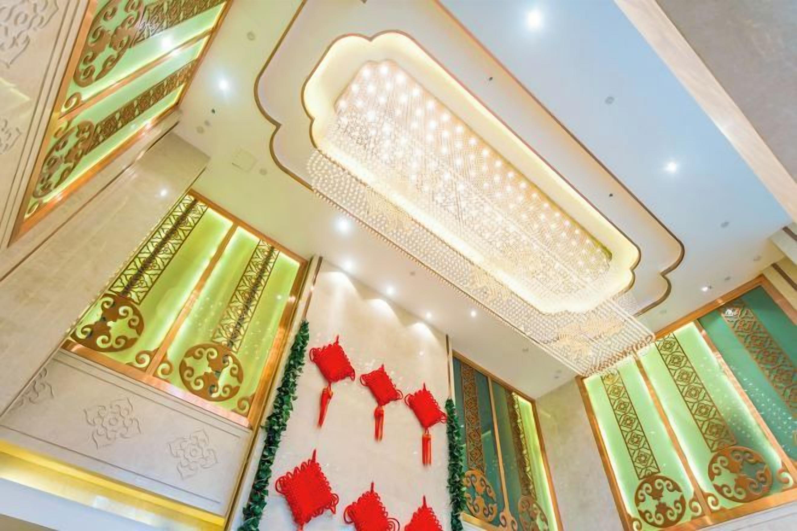 A ceiling with a decorative light fixture and patterned wall designs.