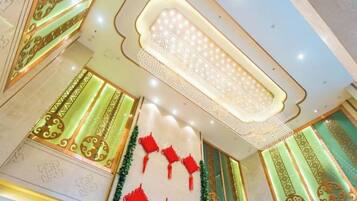 A ceiling with a decorative light fixture and patterned wall designs.