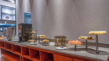 Un comptoir de buffet proposant divers plats et un distributeur d’eau.