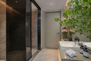 A modern bathroom with a glass shower, a white sink, and a potted plant. - Xuefu Hotel (Shenzhen Science Park Nanshan Subway Station Branch) (Shenzhen)