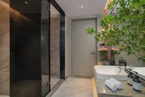 A modern bathroom with a walk-in shower, a large bathtub, and a potted plant. - Xuefu Hotel (Shenzhen Science Park Nanshan Subway Station Branch) (Shenzhen)