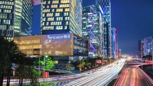 A modern building with illuminated signage, surrounded by high-rise buildings and a busy highway with light trails. - Xuefu Hotel (Shenzhen Science Park Nanshan Subway Station Branch) (Shenzhen)