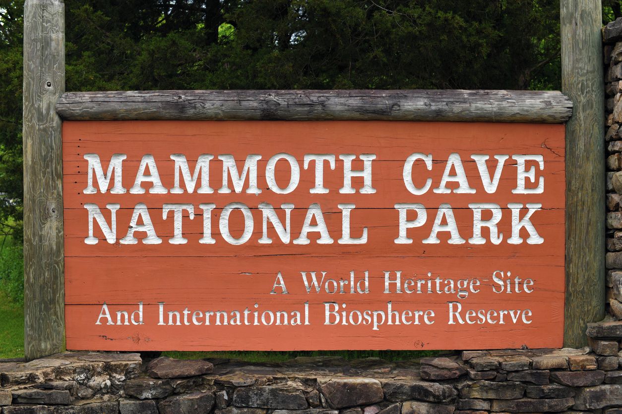 Een houten bord met de tekst 'Mammoth Cave National Park' en 'Werelderfgoed en Internationaal Biosfeerreservaat'.