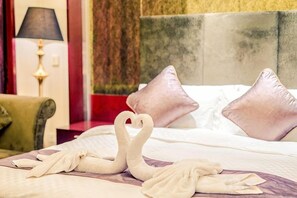 A hotel room with a bed, pillows, a lamp, and a wall with a textured pattern.