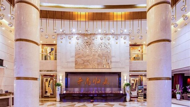 A spacious lobby with marble columns, a central decorative wall, and a reception desk. - Fengyan Jianguo Hotel (Pingyao Ancient City) (Pingyao)