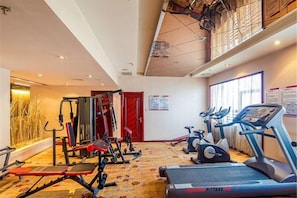 A gym with treadmills, weight machines, and a red door. - Fengyan Jianguo Hotel (Pingyao Ancient City) (Pingyao)