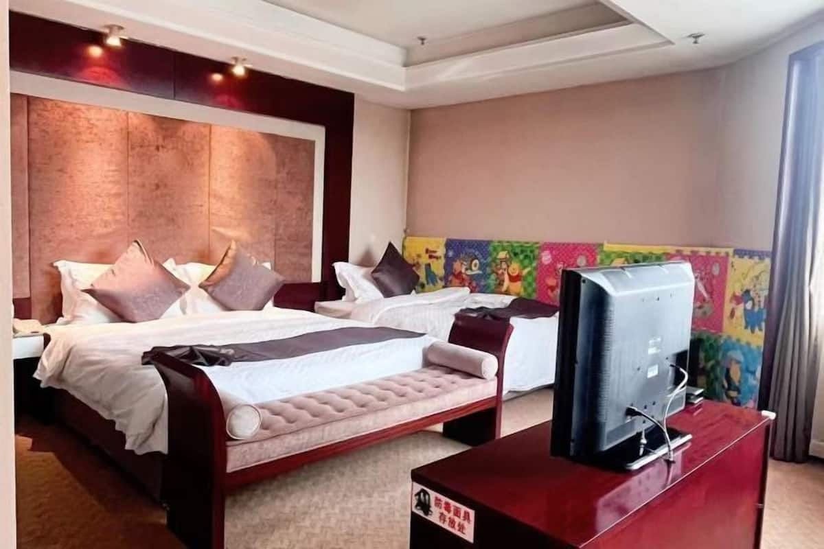Ein Hotelzimmer mit einem großen Bett, einem Fernseher und einem farbenfrohen Wandbild.