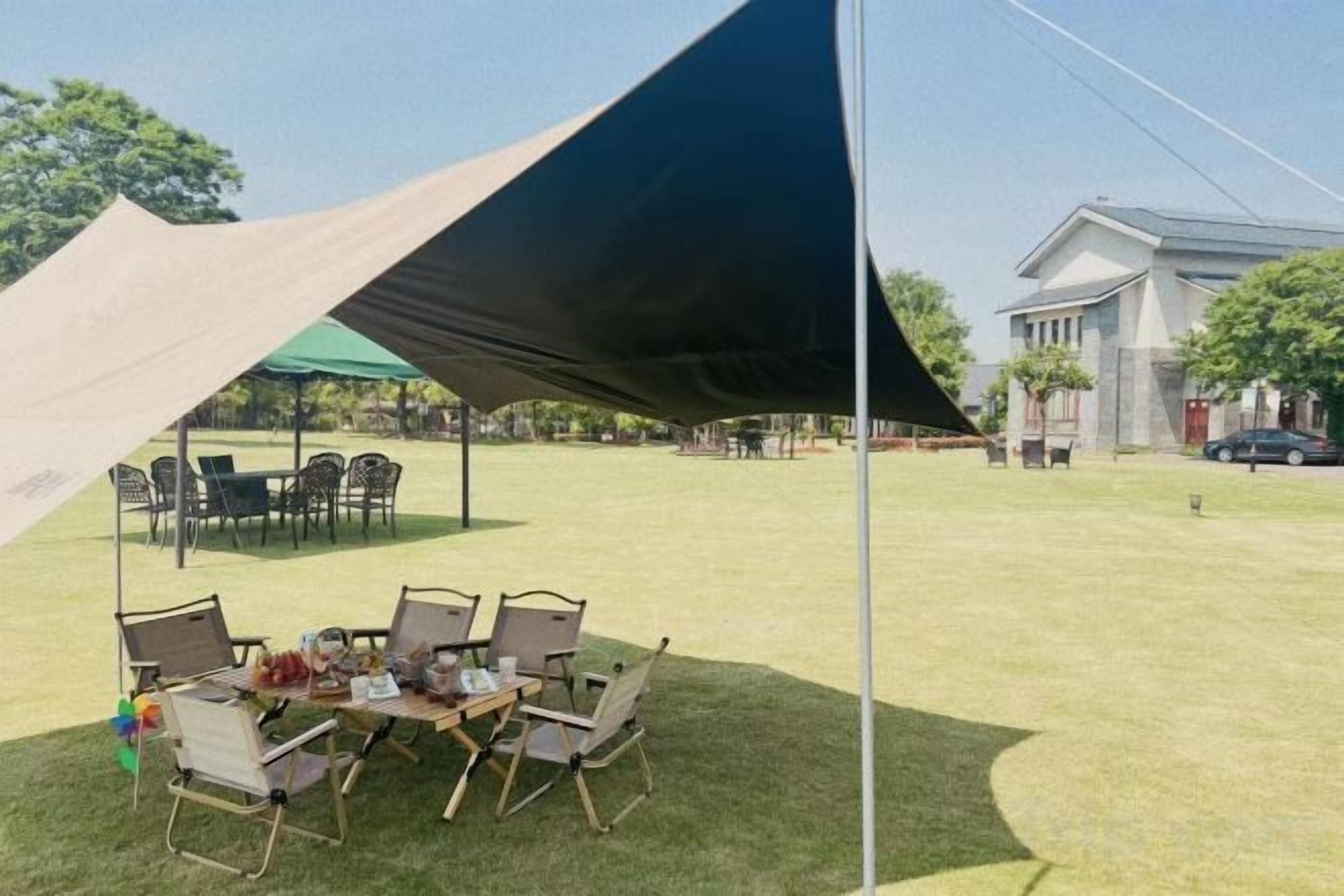 Ein Essbereich im Freien mit Tisch und Stühlen unter einem großen Zelt.