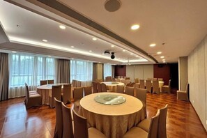 A conference room with round tables, chairs, and a large screen. - Mingzhu Lake Resort (Shanghai)