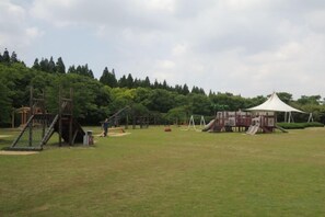 An outdoor playground with various play structures and a covered seating area. - Mingzhu Lake Resort (Shanghai)