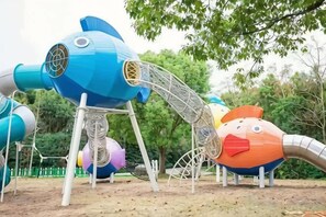 A playground with various play structures including a blue fish-shaped slide and a red and orange climbing frame. - Mingzhu Lake Resort (Shanghai)