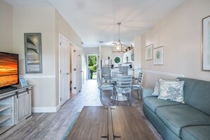 A modern living room with a television, sofa, and dining area. - Duck Key Waterfront Villa w/ 2 Free Kayaks & near 2 Public Marinas (Marathon)