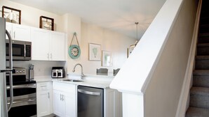 A modern kitchen with white cabinets, stainless steel appliances, and a dishwasher.