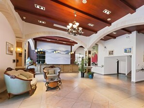 A spacious lobby with a high ceiling, a chandelier, and a large wall mural. - GreenTree Alliance Hotel (Shanghai Baoshan District Meilan Lake Yueluo Road) (Shanghai)