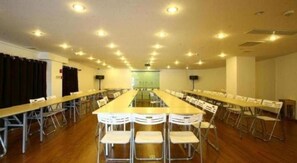 A conference room with a long table, chairs, and a stage. - GreenTree Alliance Hotel (Shanghai Baoshan District Meilan Lake Yueluo Road) (Shanghai)
